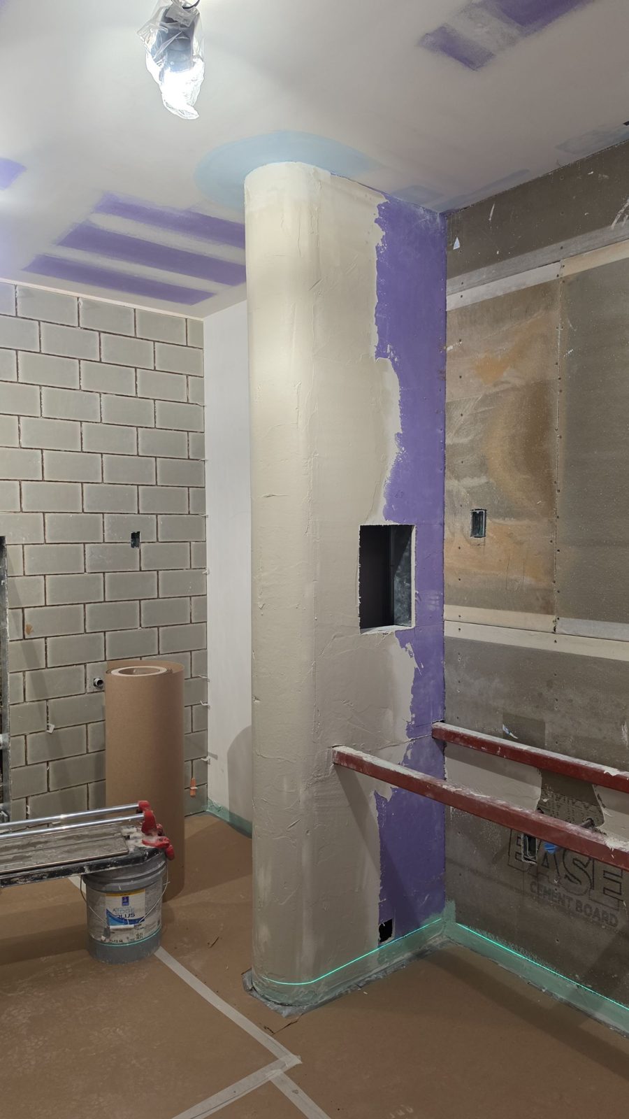 Restroom before tile — cement board walls and a curved column with a niche cut in