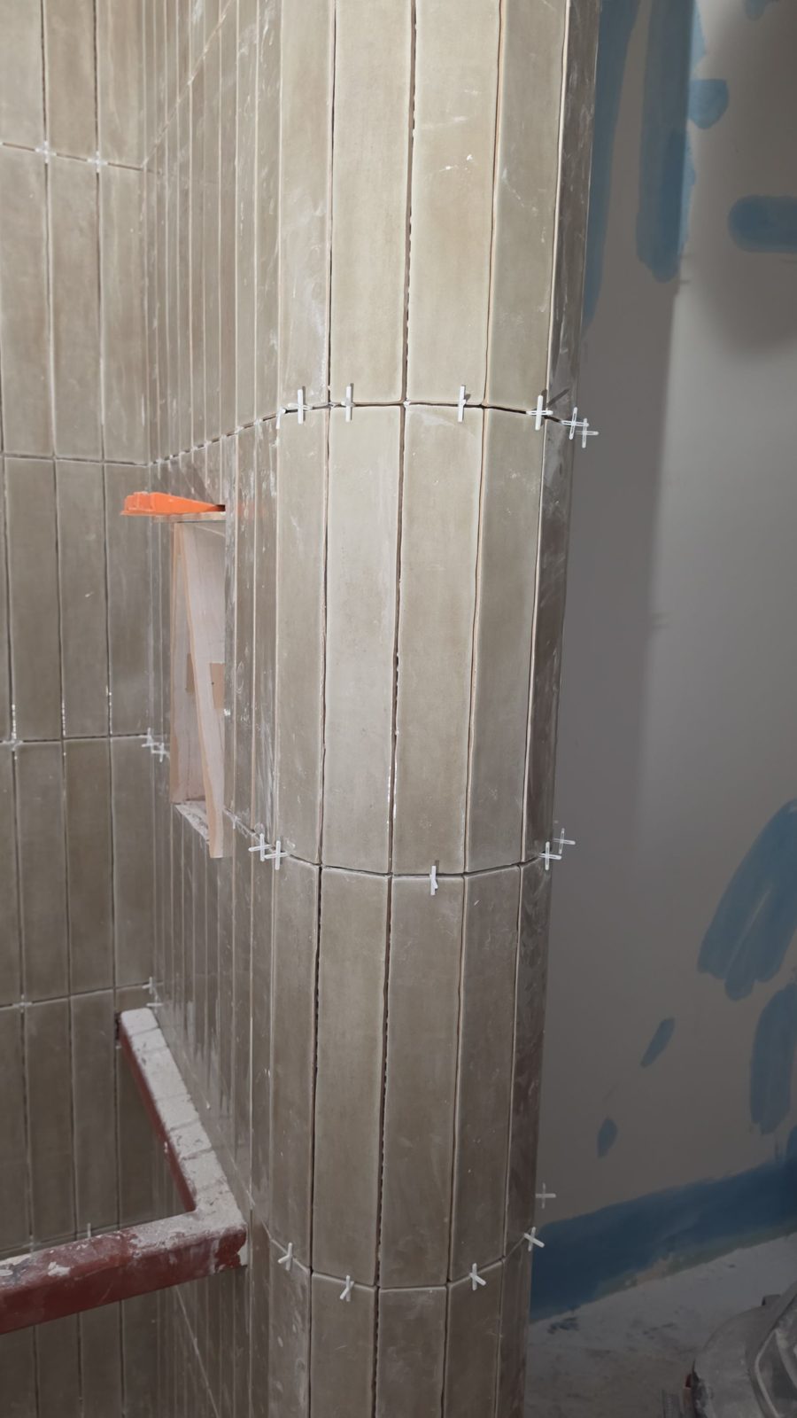 Vertical-stack tile being wrapped around the curved column with spacers in place