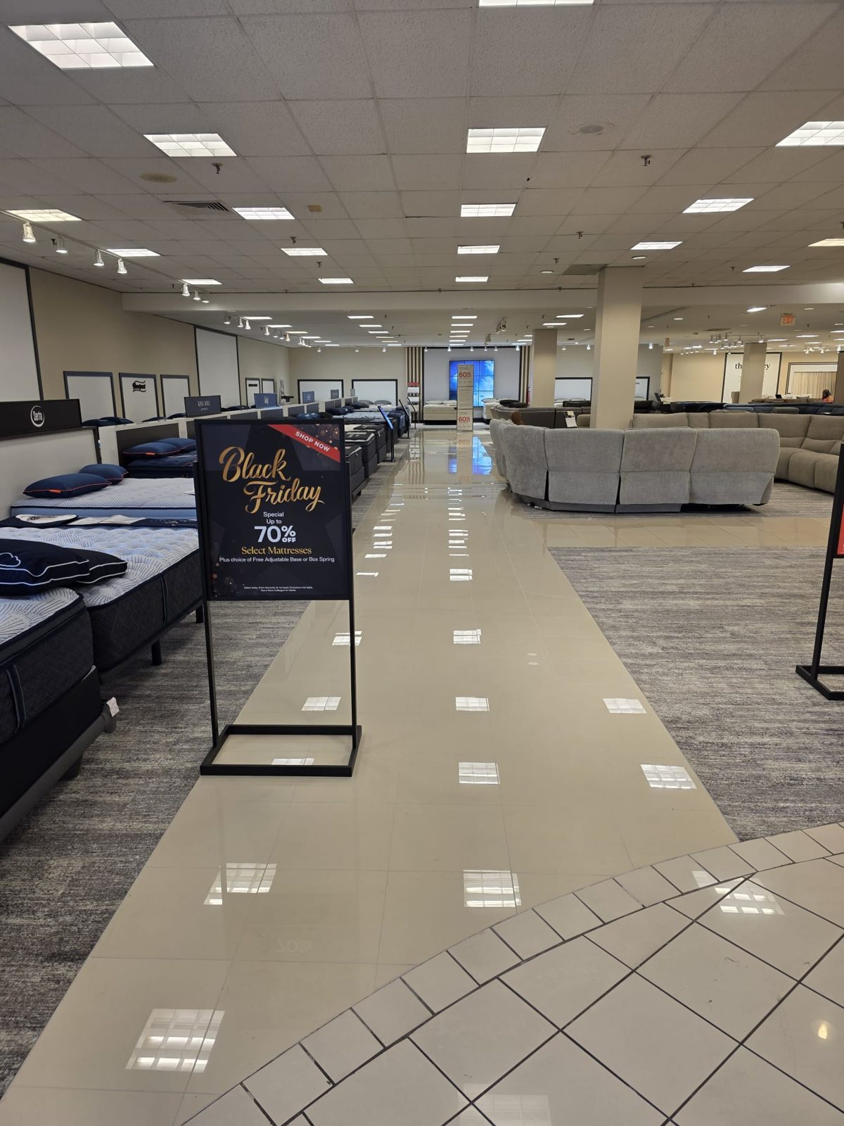 Finished polished porcelain aisle between mattress and furniture displays, store open